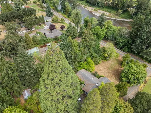 an aerial view of lake residential house with outdoor space and trees around