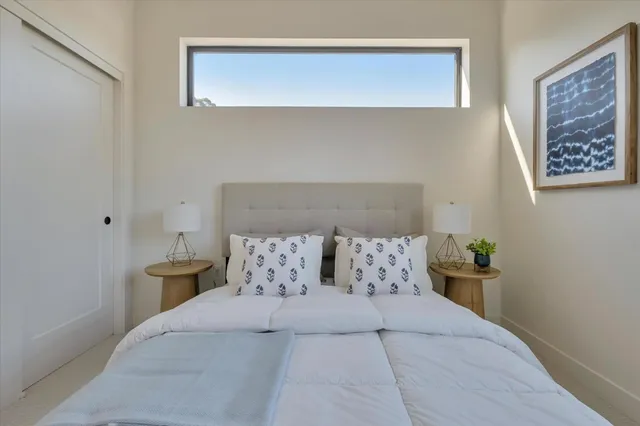 a large bed sitting in a bedroom next to a lamp