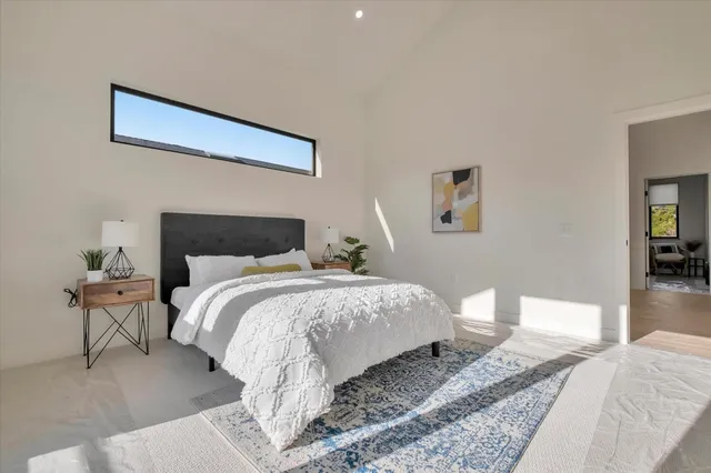 a bedroom with a bed and wooden floor