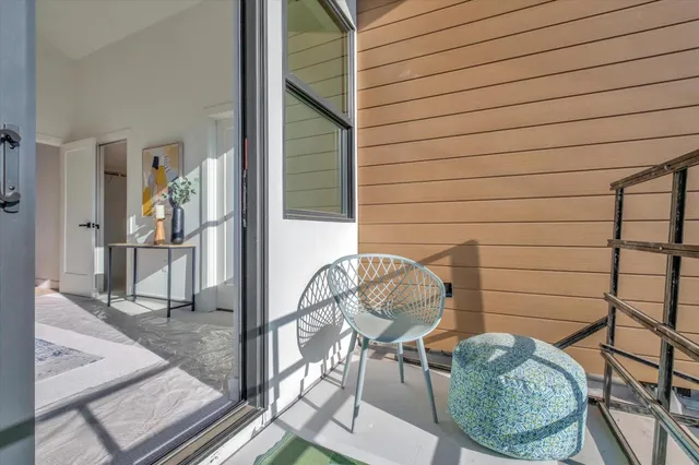 a balcony with chairs and glass door