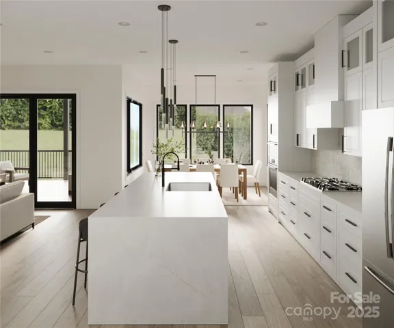 a large white kitchen with granite countertop a large window and a sink