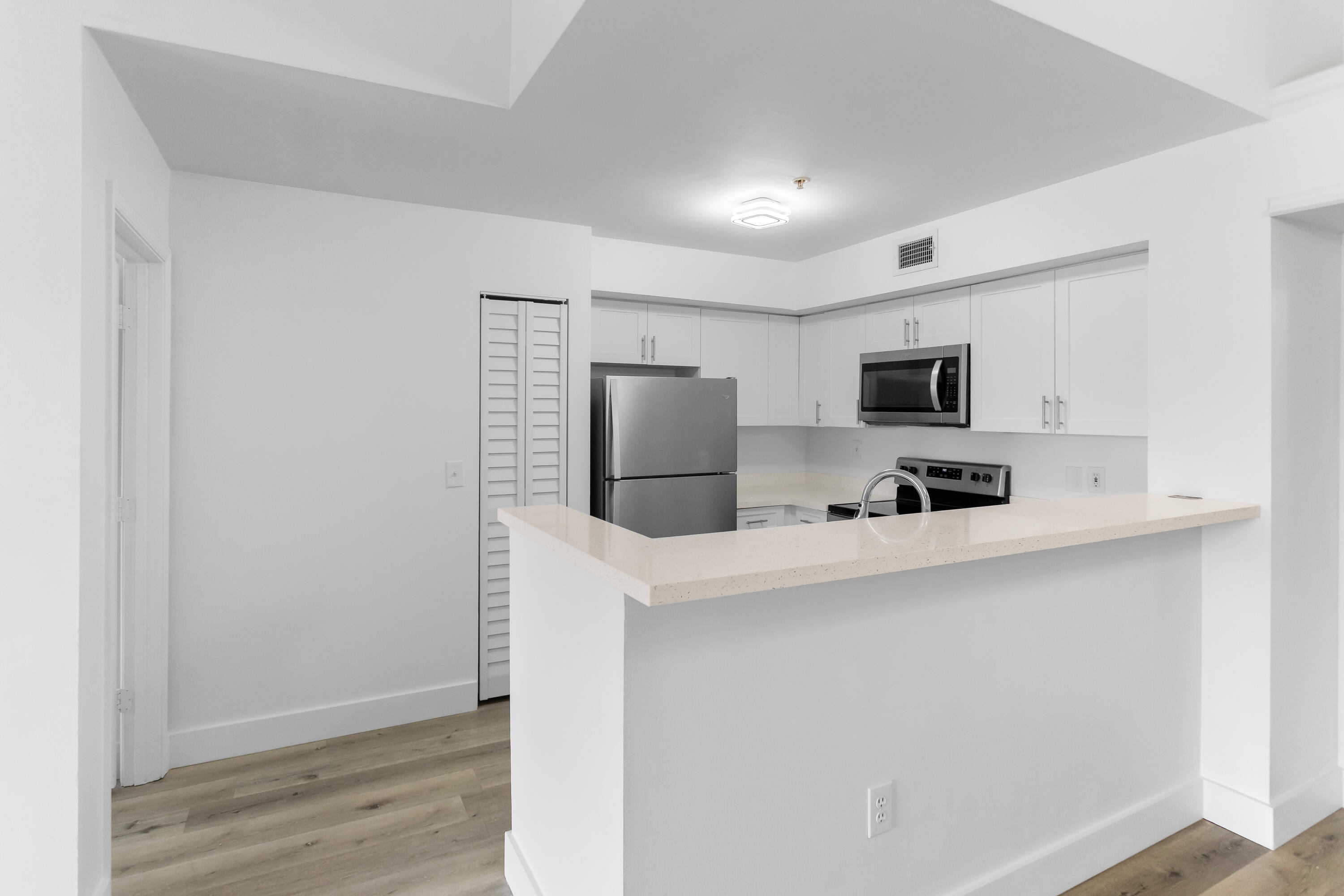 2113 Renaissance Boulevard, Unit 306 Miramar, FL 33025 - Photo 13 of 59 a kitchen with stainless steel appliances a refrigerator microwave stove sink and cabinets