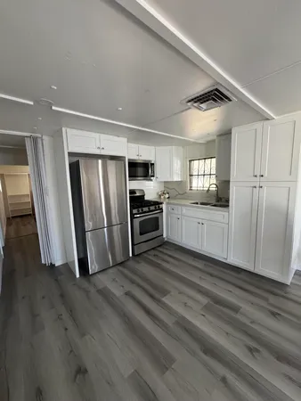a view of a refrigerator in kitchen and wooden floor
