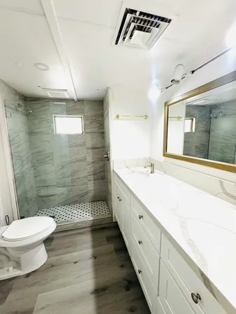 a bathroom with a double vanity sink toilet and shower