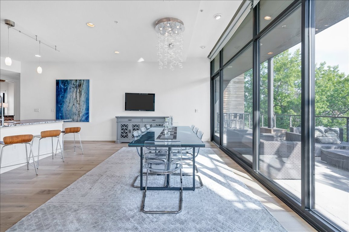 1101 Ivean Pearson Road, Unit A102 Lago Vista, TX 78645 - Photo 8 of 31 Dining area with a wall of windows, light wood finished floors, a chandelier, and recessed lighting