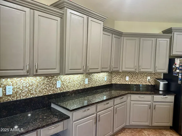 a kitchen with granite countertop a sink stainless steel appliances and cabinets