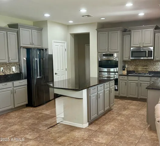 a kitchen with stainless steel appliances granite countertop a refrigerator stove microwave and sink