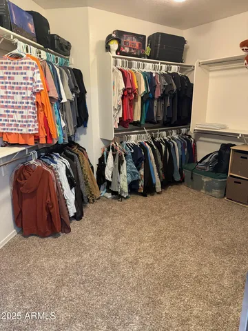 a view of walk in closet with clothes and shoes