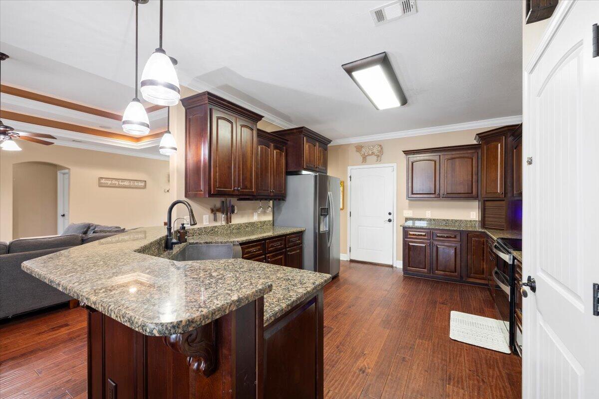 7938 Steel Mill Creek Road Laurel Hill, FL 32567 - Photo 11 of 33 a kitchen with stainless steel appliances granite countertop a sink refrigerator and cabinets