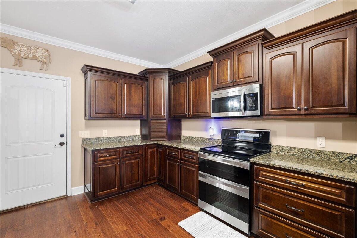 7938 Steel Mill Creek Road Laurel Hill, FL 32567 - Photo 12 of 33 a kitchen with stainless steel appliances granite countertop a stove and a microwave