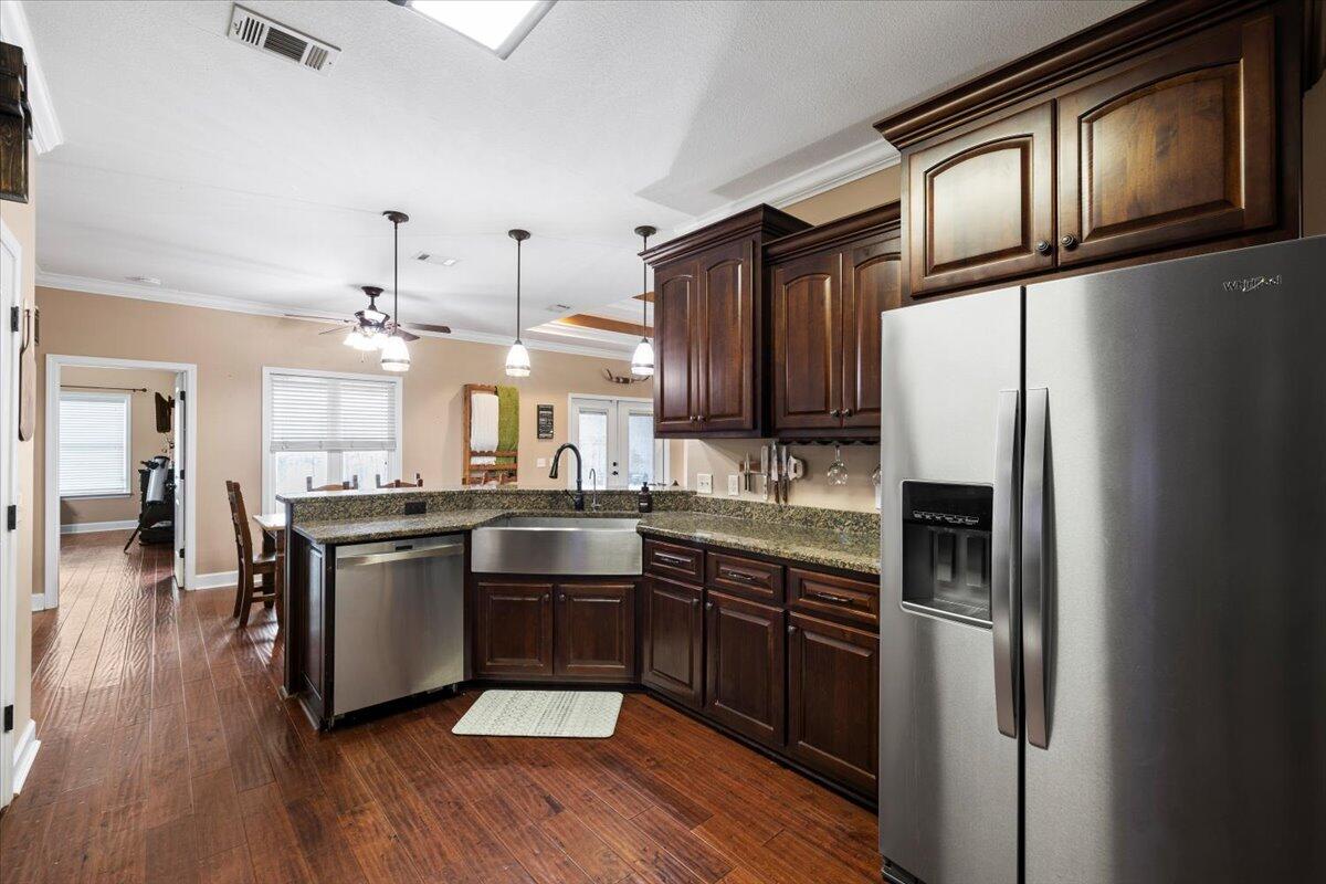 7938 Steel Mill Creek Road Laurel Hill, FL 32567 - Photo 13 of 33 a kitchen with granite countertop stainless steel appliances and wooden floor