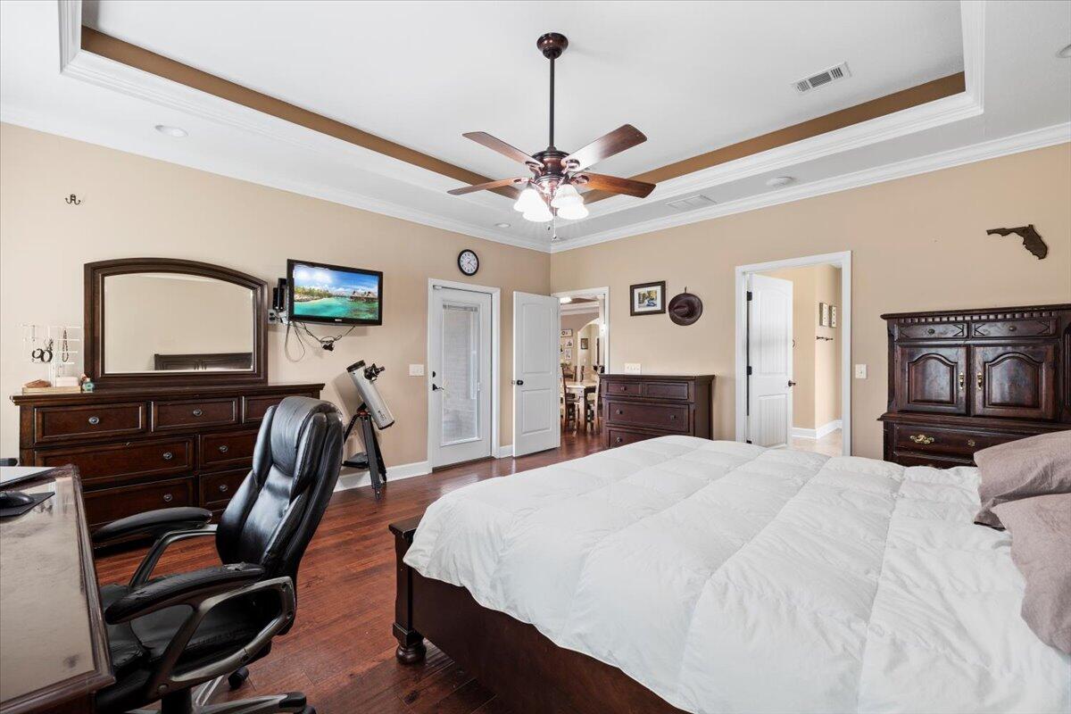 7938 Steel Mill Creek Road Laurel Hill, FL 32567 - Photo 15 of 33 a bedroom with a bed a dresser and flat screen tv