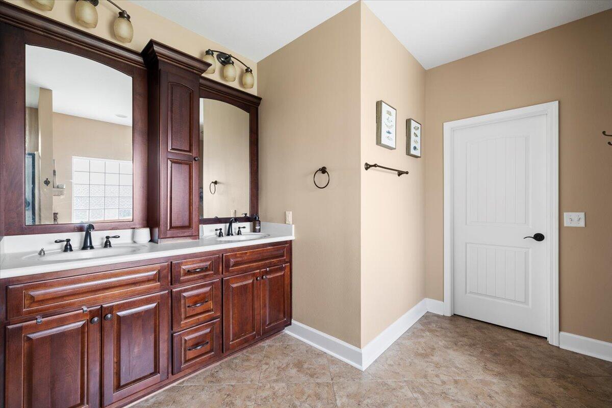 7938 Steel Mill Creek Road Laurel Hill, FL 32567 - Photo 17 of 33 a bathroom with a double vanity sink and a mirror