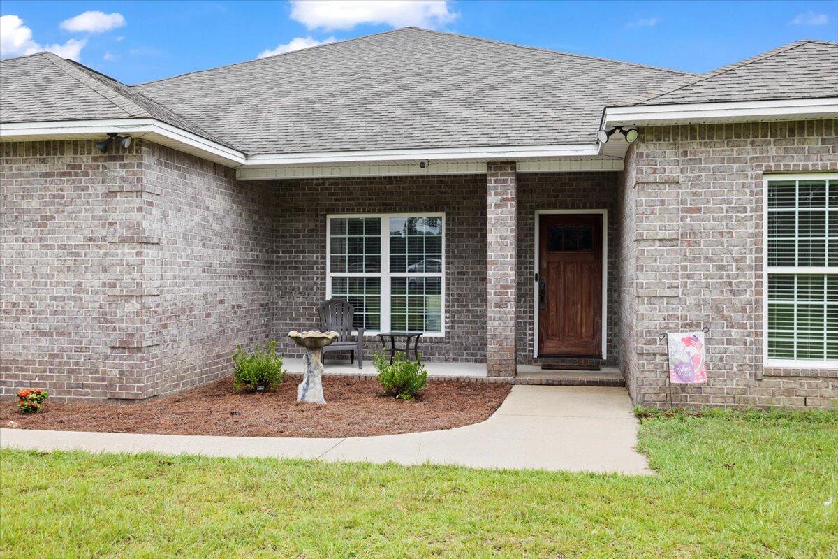 7938 Steel Mill Creek Road Laurel Hill, FL 32567 - Photo 2 of 33 a front view of a house with garden