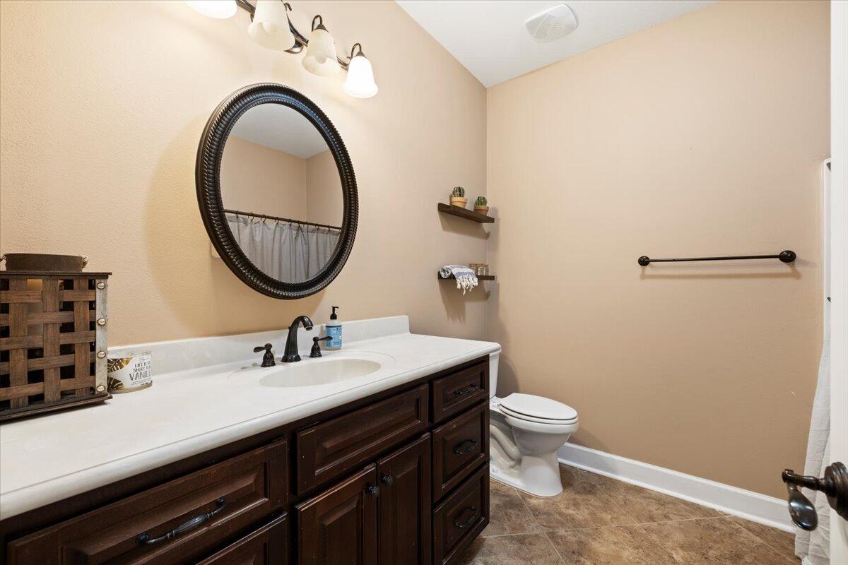 7938 Steel Mill Creek Road Laurel Hill, FL 32567 - Photo 24 of 33 a bathroom with a sink a toilet and a mirror