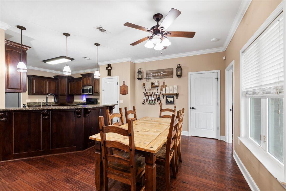 7938 Steel Mill Creek Road Laurel Hill, FL 32567 - Photo 10 of 33 a view of a dining room with furniture and wooden floor