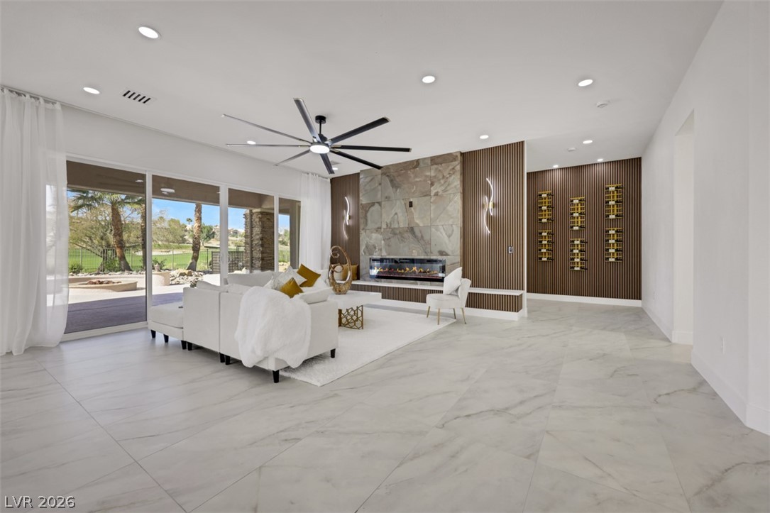 5015 Rivedro Street Las Vegas, NV 89135 - Photo 22 of 91 A spacious, naturally illuminated living area with a contemporary fireplace and abundant natural light.