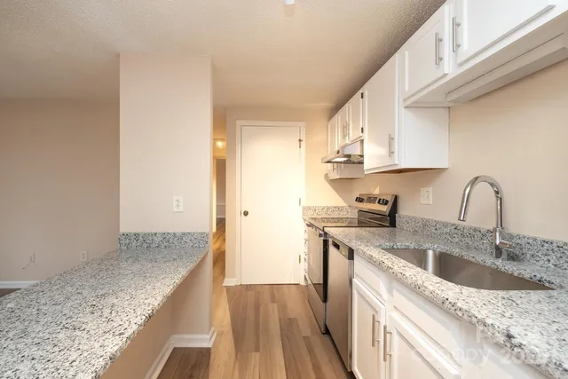a kitchen with stainless steel appliances granite countertop a sink stove and cabinets