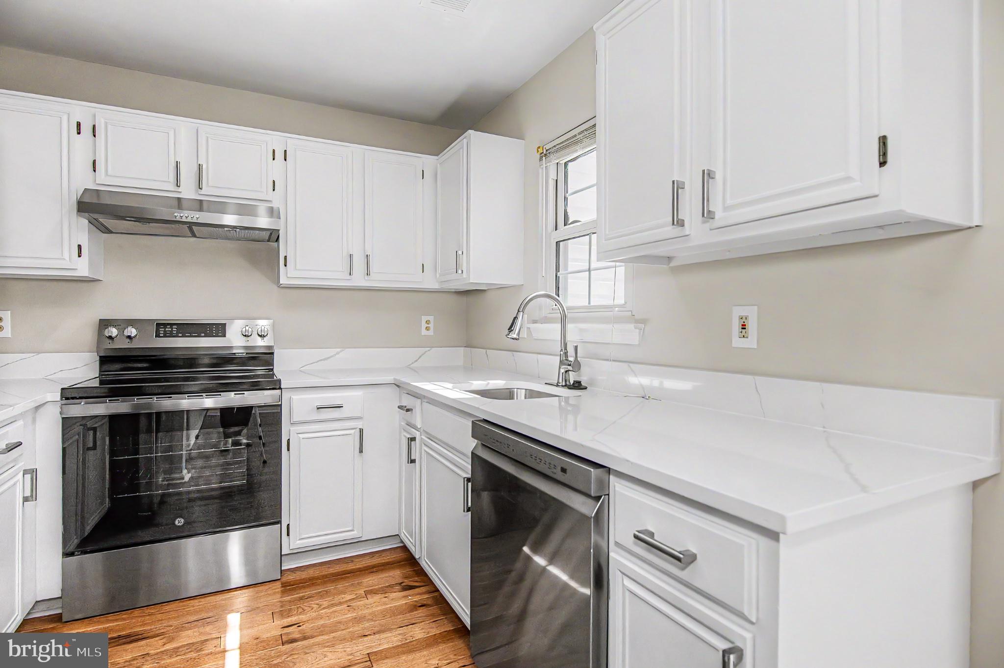 13993 Gunners Place Centreville, VA 20121 - Photo 21 of 43 a kitchen with stainless steel appliances granite countertop a stove a sink and white cabinets