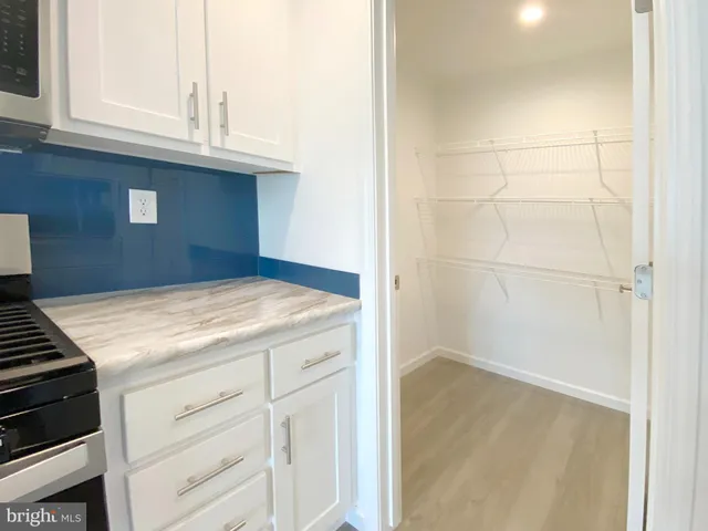 a kitchen that has a lot of cabinets and wooden floor