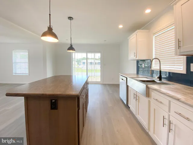a kitchen with stainless steel appliances granite countertop a stove a sink and a wooden floors