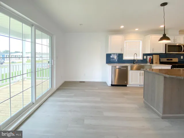 a open kitchen with stainless steel appliances granite countertop a stove top oven a sink a counter space and cabinets