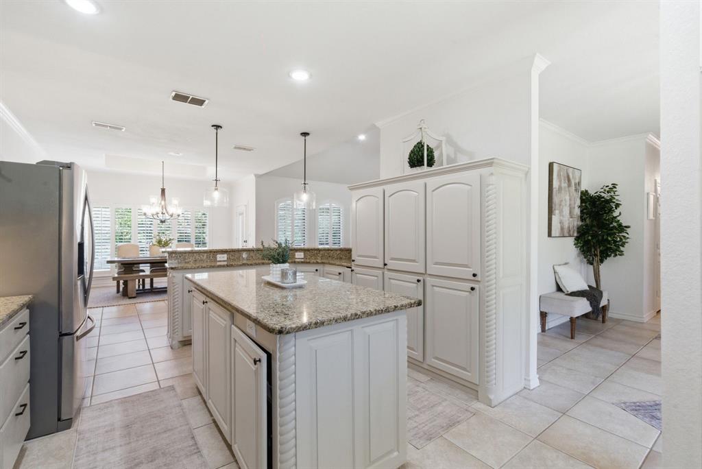 405 Zion Hill Road Weatherford, TX 76088 - Photo 9 of 38 Kitchen with stainless steel fridge with ice dispenser, decorative light fixtures, a center island, light stone countertops, and light tile patterned floors