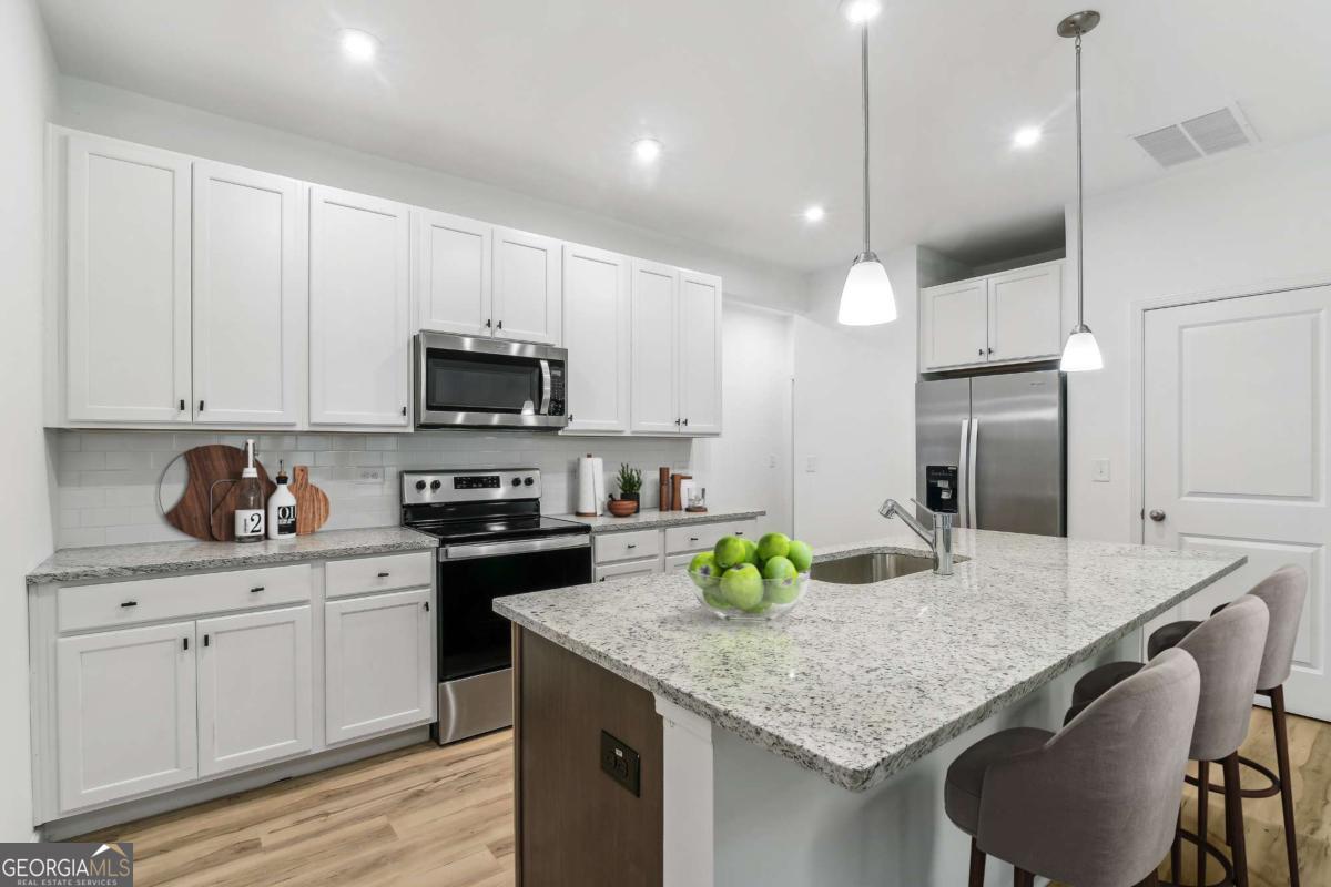 1638 Salinger Court, Unit 1638 Stockbridge, GA 30281 - Photo 5 of 18 a kitchen with granite countertop cabinets and steel stainless steel appliances