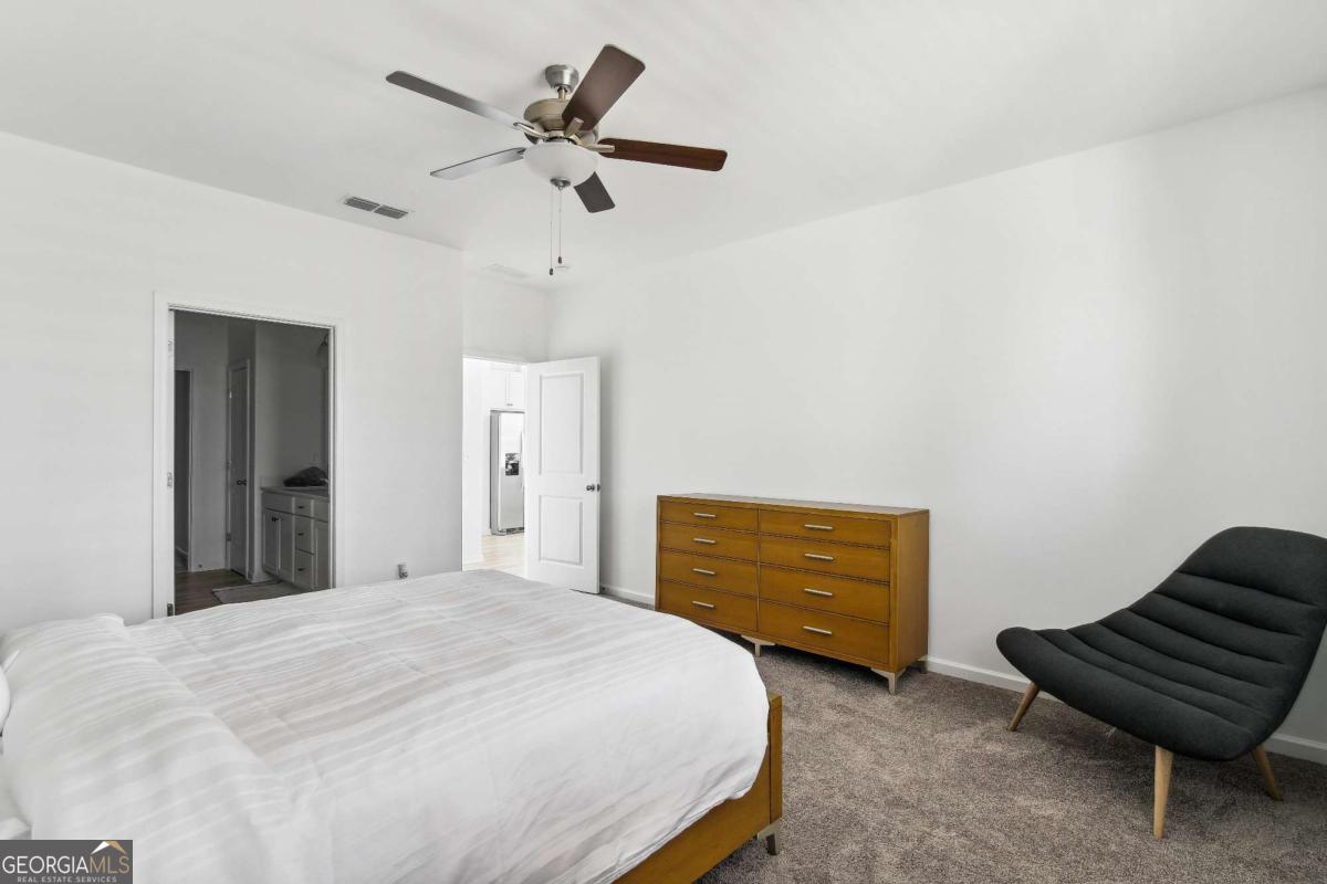 1638 Salinger Court, Unit 1638 Stockbridge, GA 30281 - Photo 10 of 18 a bedroom with a bed and a dresser