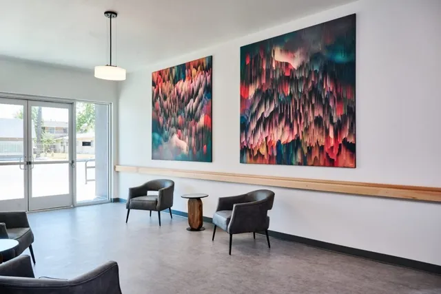 a living room with furniture and a painting on the wall