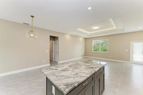 a view of a kitchen island a sink wooden floor and a window