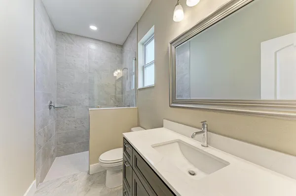 a bathroom with a sink a toilet and shower