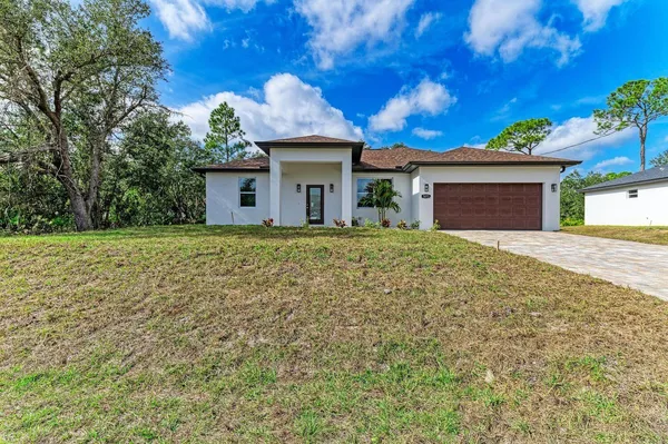 a front view of a house with a yard and garage