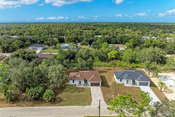 an aerial view of a house with a yard basket ball court and outdoor seating