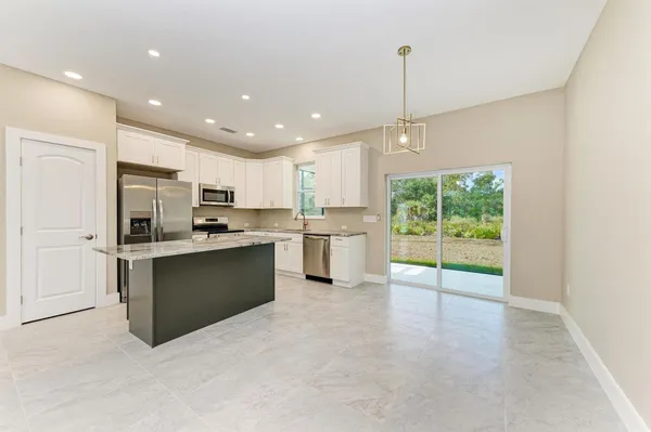 a kitchen with stainless steel appliances granite countertop a refrigerator sink and cabinets