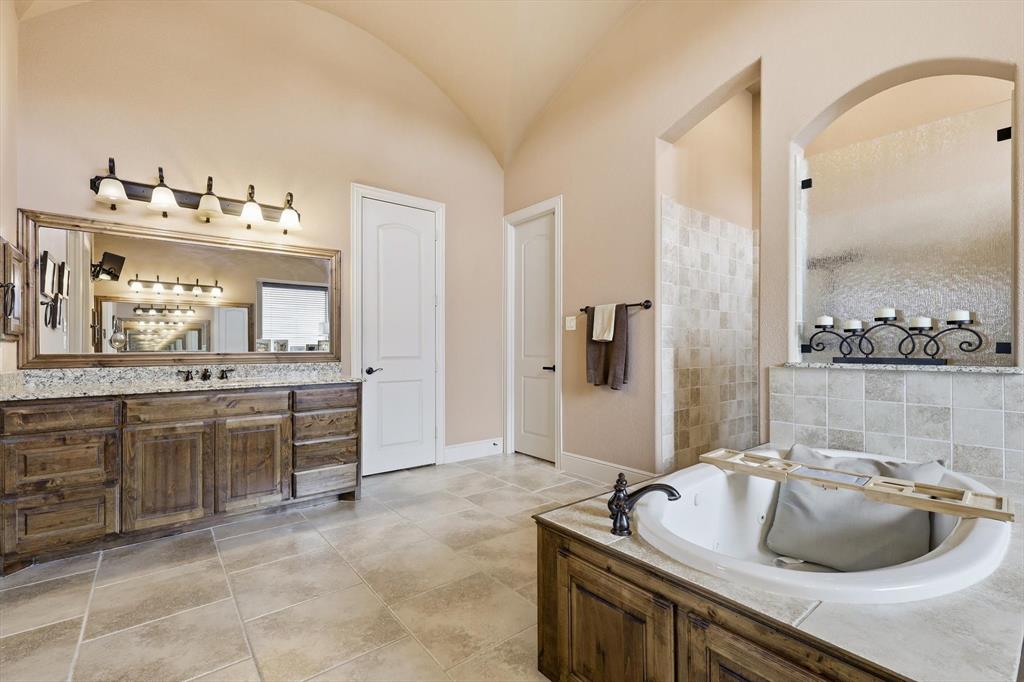 406 Spurgin Road Lucas, TX 75002 - Photo 16 of 39 Bathroom featuring vanity, a tile shower, a bath, and vaulted ceiling