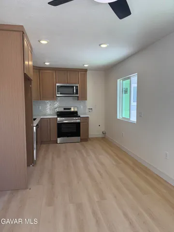 a kitchen with a refrigerator and a stove top oven