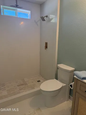 a white toilet sitting next to a bath tub