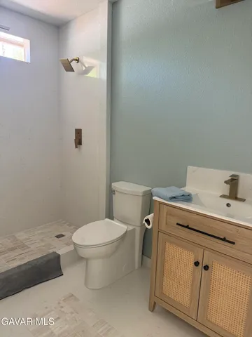 a bathroom with a granite countertop toilet and a sink