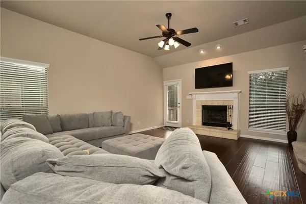 a living room with furniture a flat screen tv and a fireplace