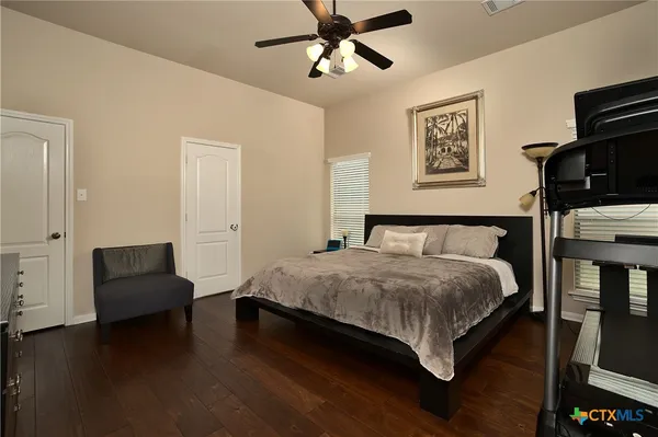 a bedroom with a bed wooden floor and window