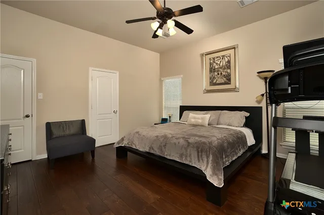 a bedroom with a bed wooden floor and window