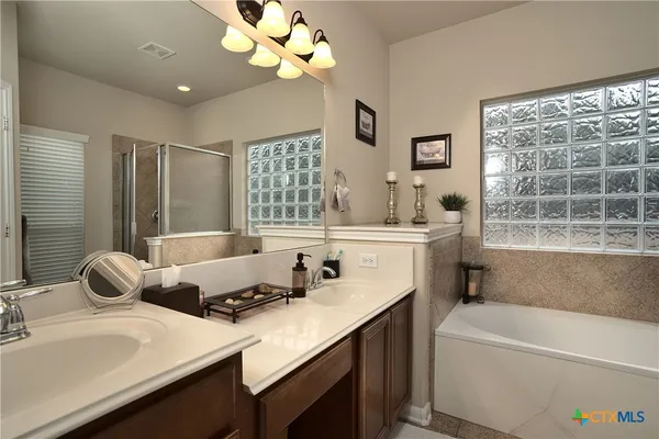 a bathroom with a tub sink and mirror