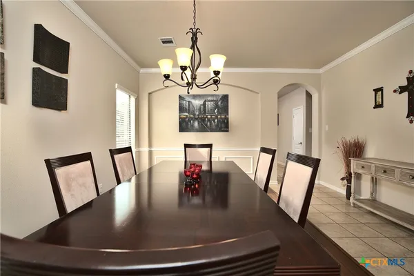 a view of a dining room with furniture a chandelier and wooden floor