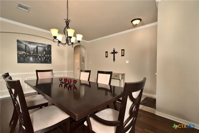 a view of a dining room with furniture and chandelier