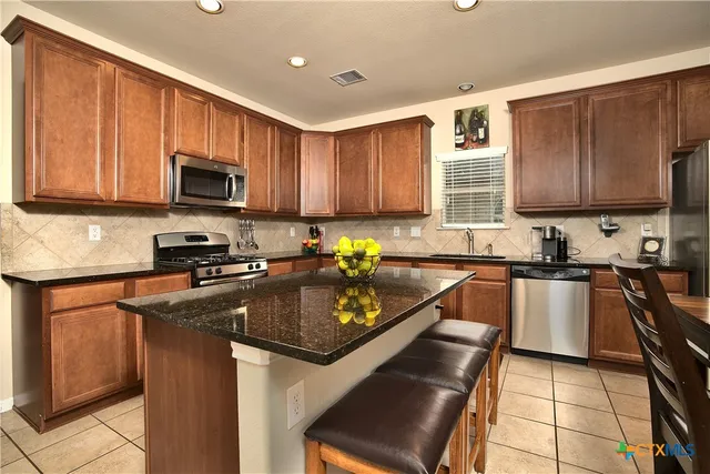 a kitchen with granite countertop a stove sink microwave and cabinets