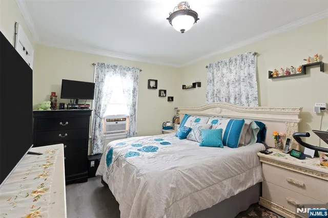 a bedroom with a bed and a flat tv screen on dresser