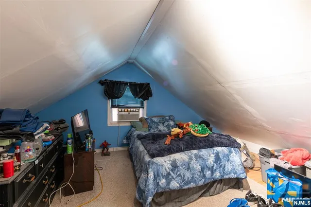 a bedroom with bed and a lamp on the dresser