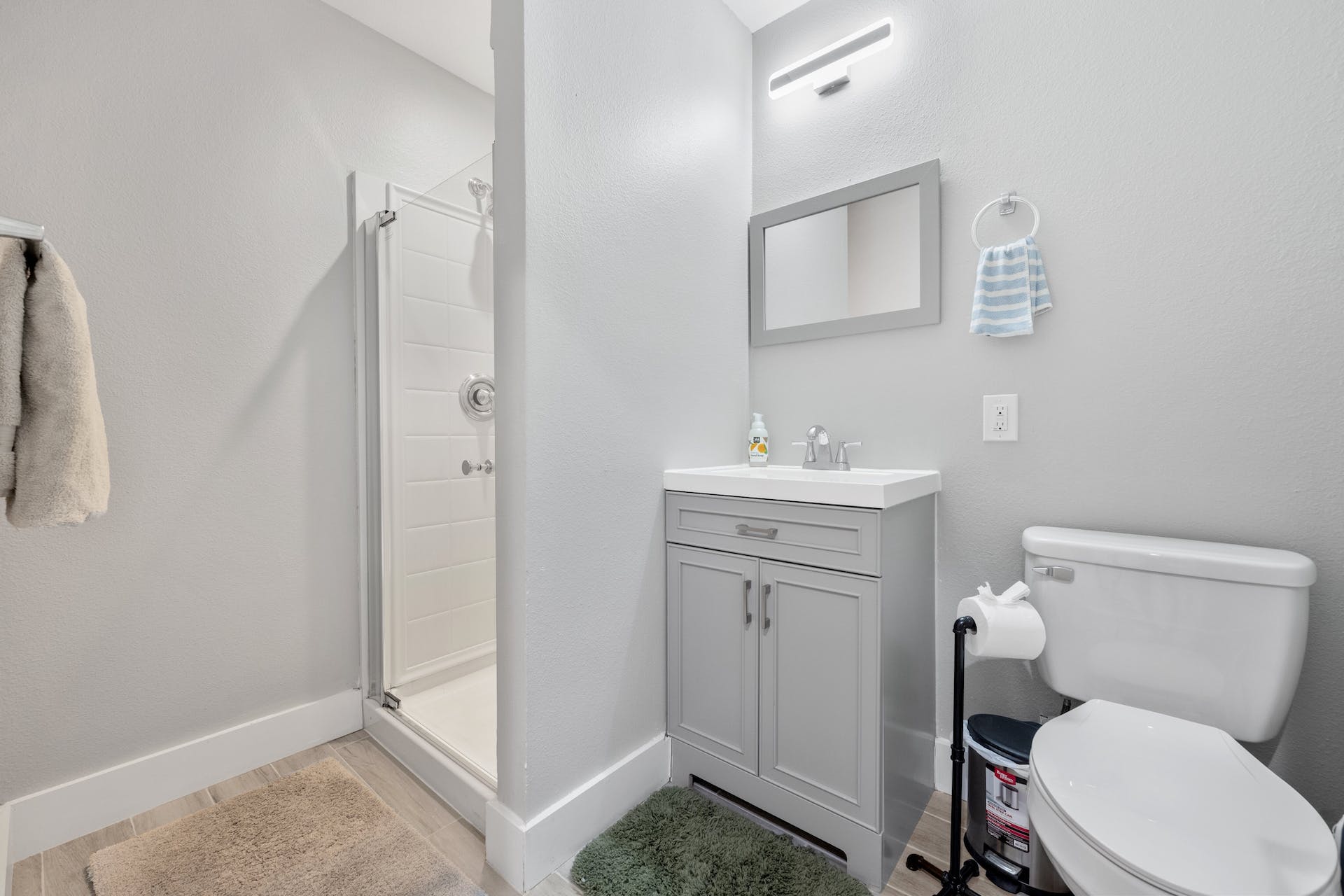1400 Chippeway Lane Austin, TX 78745 - Photo 12 of 24 Bathroom with a shower stall, vanity, a textured wall, and light wood-style flooring