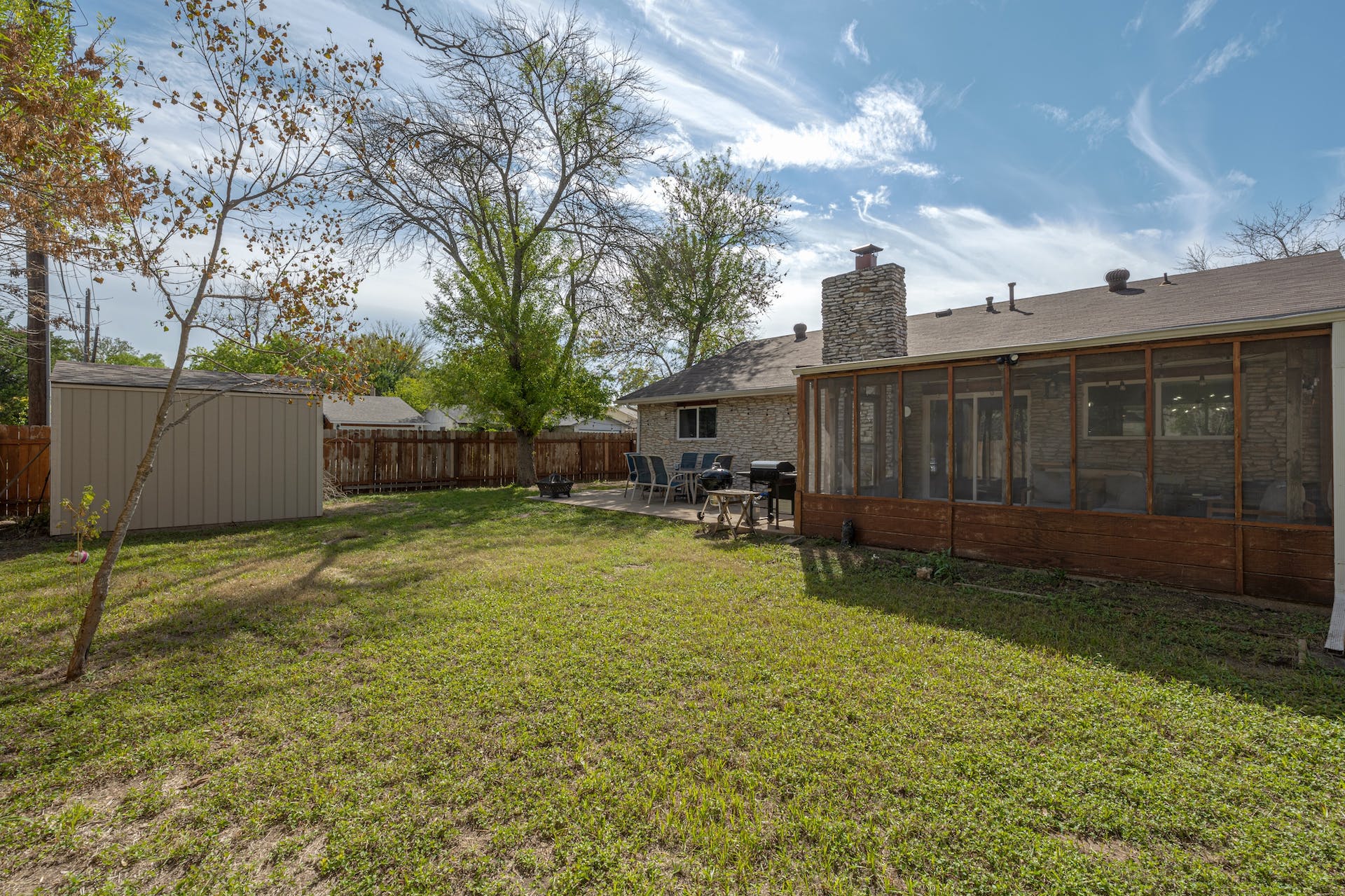 1400 Chippeway Lane Austin, TX 78745 - Photo 22 of 24 Fenced backyard with a storage shed, a sunroom, and a patio